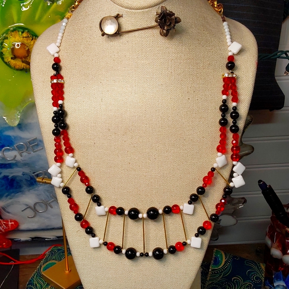 Artisan, black spinal , milk glass  and red glass.  In gold tone 22 24 in